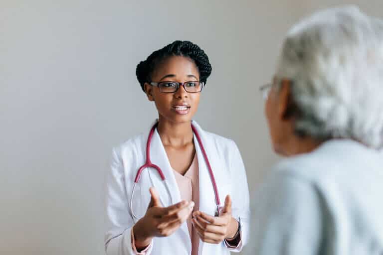 Beautiful young female doctor explaining to senior patient