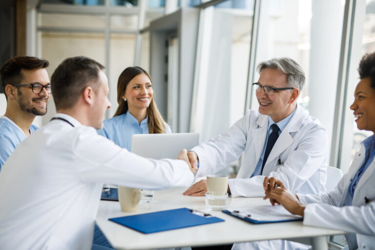 Shot of doctors shaking hands during a meeting in a hospital