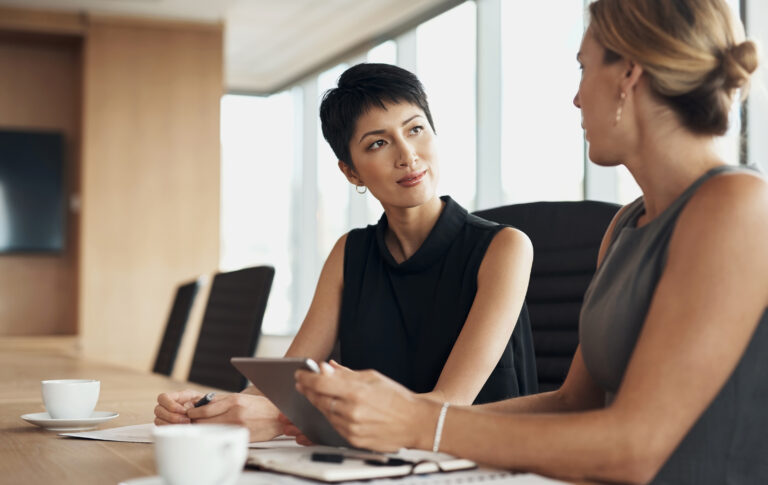 Tablet, teamwork and business women in the boardroom for a meeting, planning a strategy for company management. Collaboration, coaching and training with a female leader speaking to a colleague