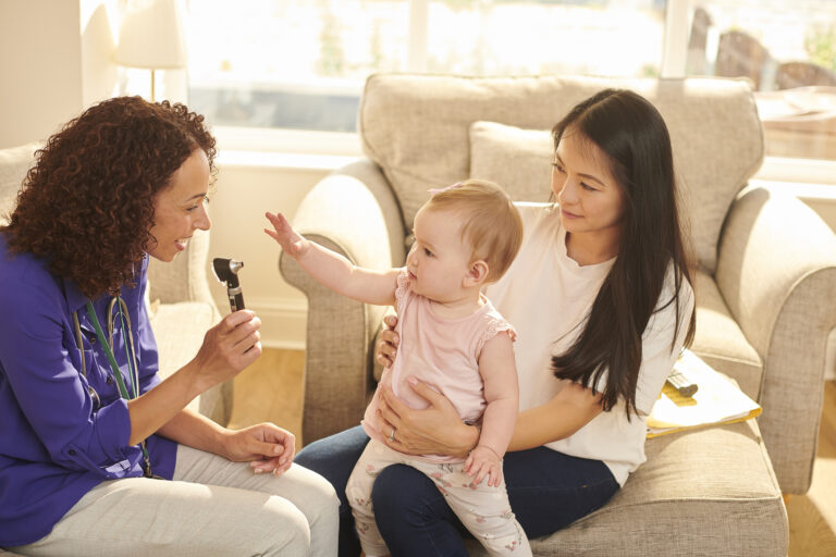 female doctor making a house call to new mum and baby