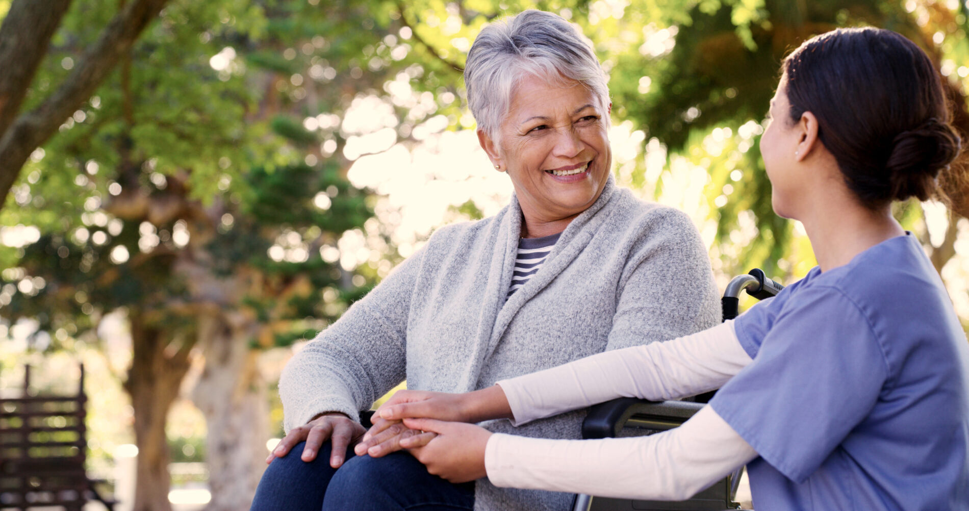 Shot of a young nurse taking an elderly patient on a walk in a garden