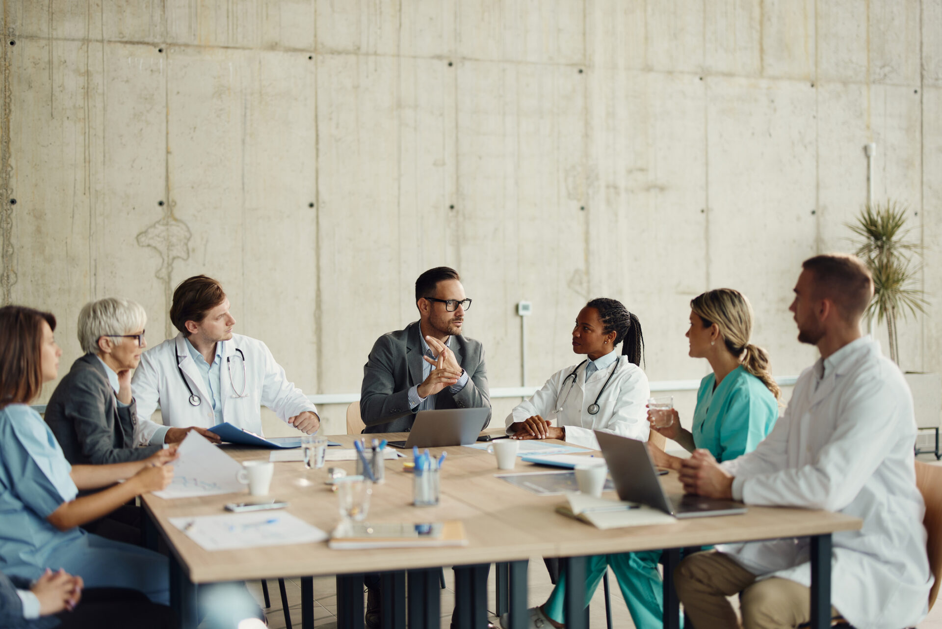 Group of doctors having a meeting with administrators in hospital.